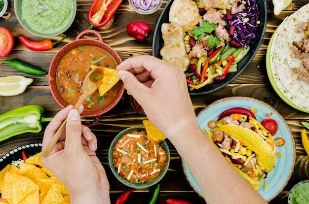 Mexican food table with hands grabbing food