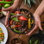 Fajitas ingredients on a table with a hand holding them