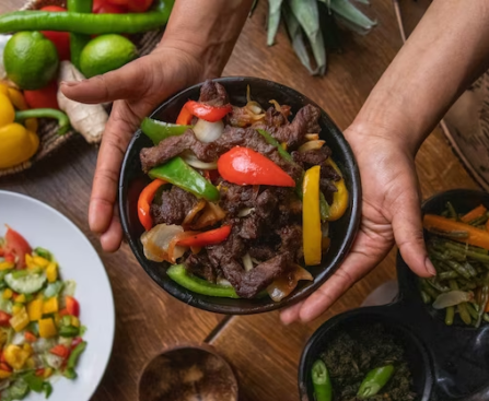 Fajitas ingredients on a table with a hand holding them